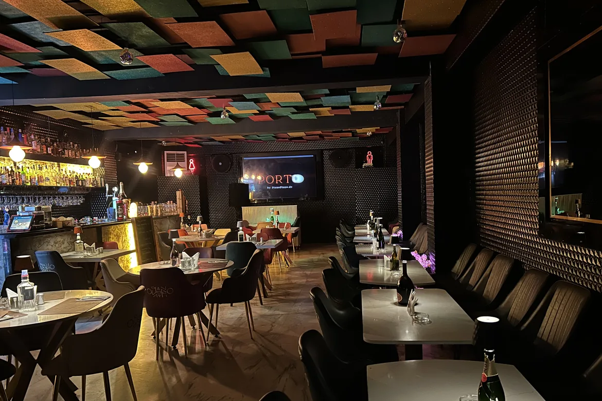 Le premier étage : le bar, les tables de marbre et le plafond de panneaux colorés.