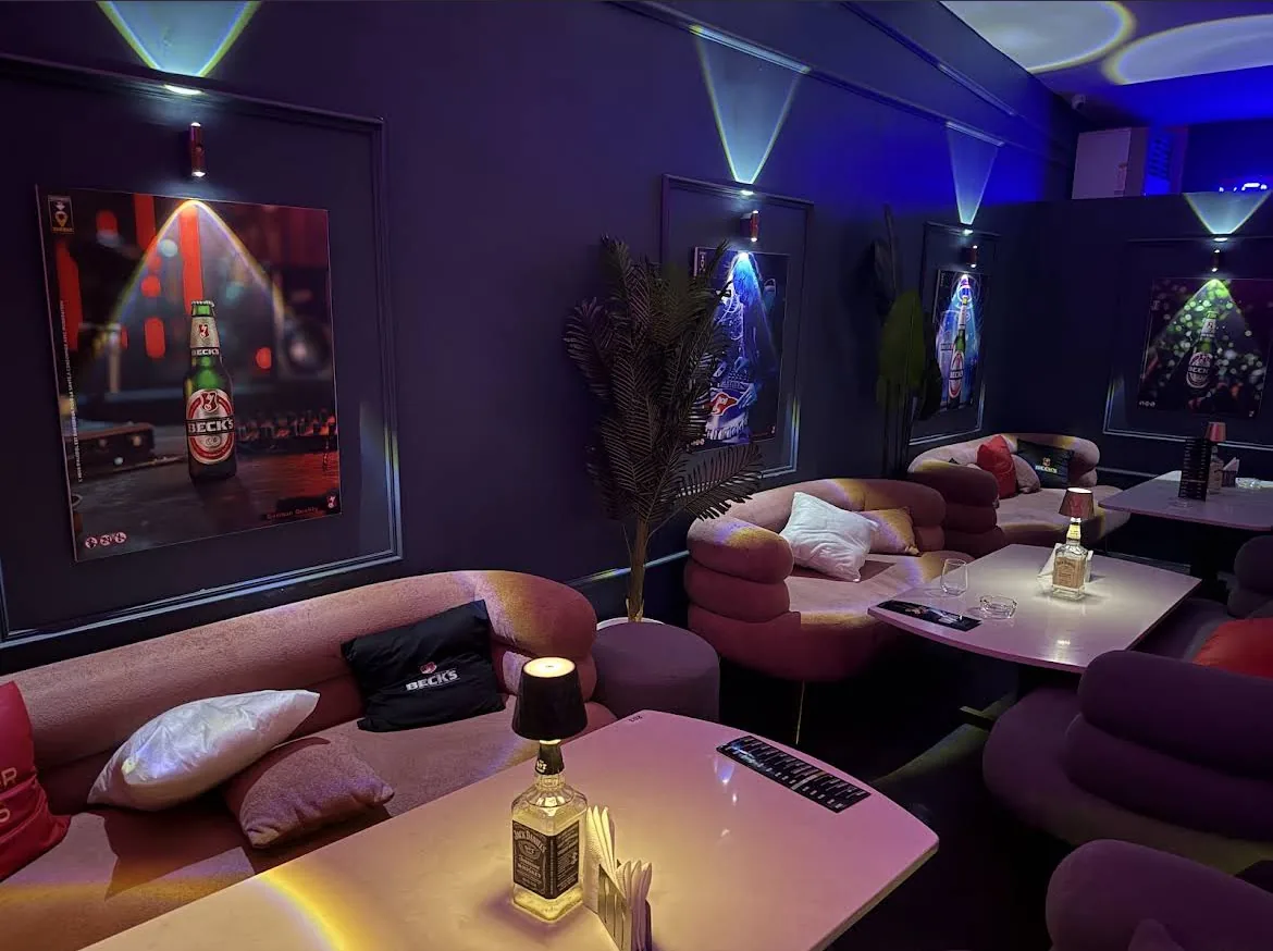 Le salon intérieur de PianoPiano.dz, banquettes en velours et lumière colorée.